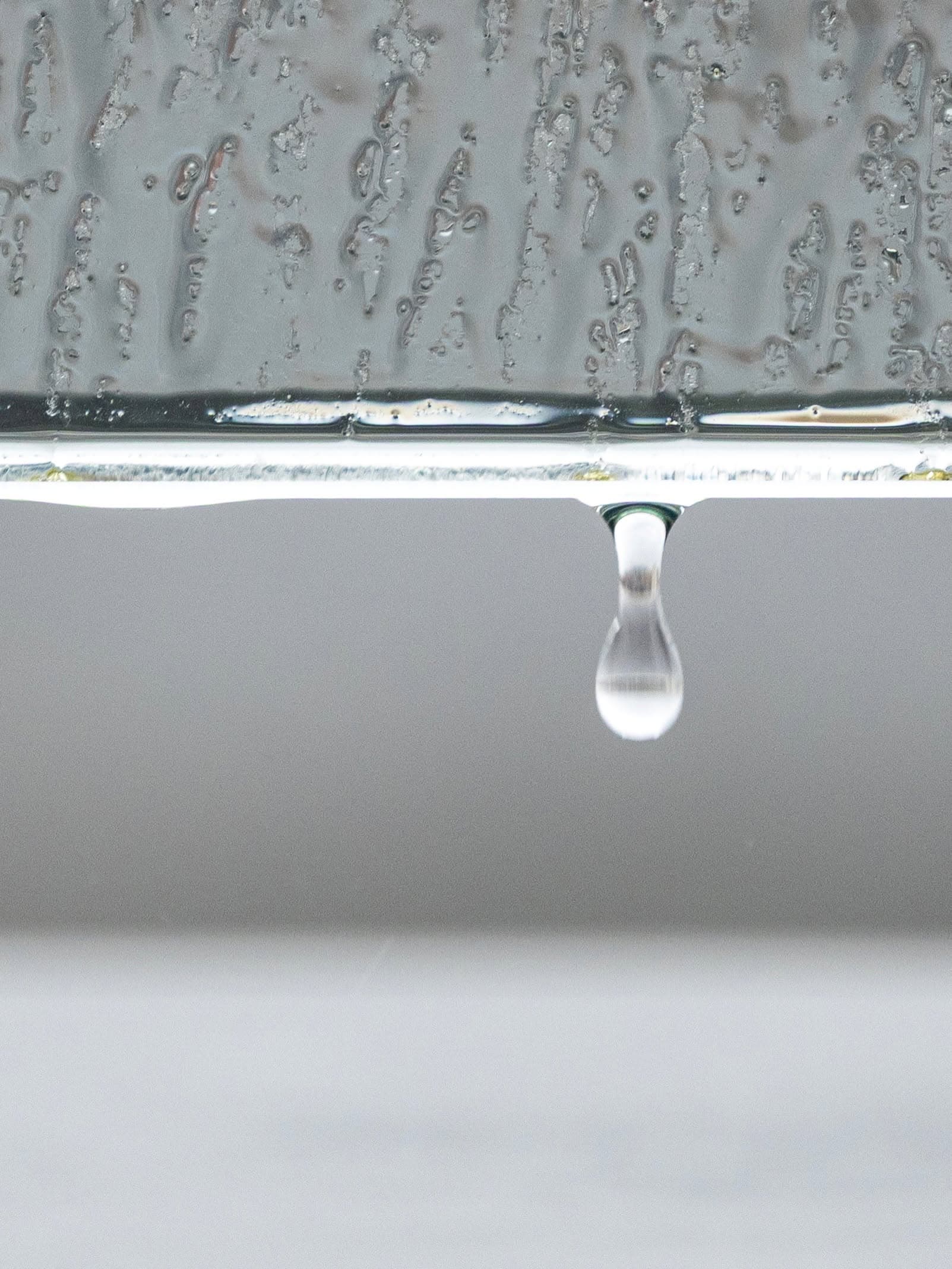 Waterdruppel die van een rand valt